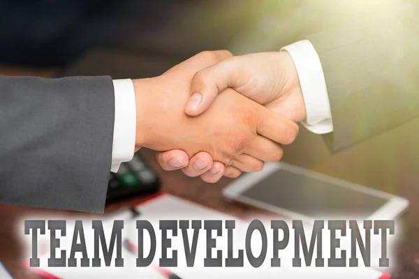 Hand writing sign Team Development. Conceptual photo the enhancement of the effectiveness of work groups Two Professional Well-Dressed Corporate Businessmen Handshake Indoors — Stock Photo, Image