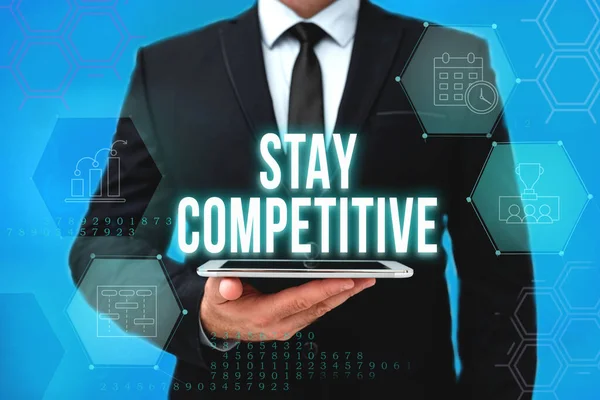 Segno di testo che mostra Stay Competitive. Idea di business buona o migliore rispetto ad altri che vendono lo stesso prodotto Man In Office Uniform Holding Tablet Visualizza la nuova tecnologia moderna. — Foto Stock