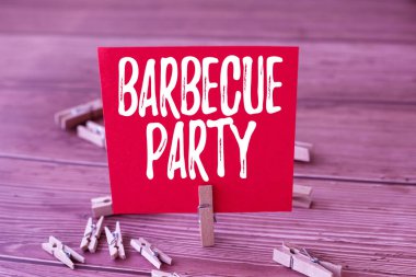 Barbekü Partisini sunan metin başlığı. İş dünyası açık hava partisi. Yemek ızgarada ya da şöminenin üstünde pişiyor. Etrafı çamaşır mandallarıyla çevrili..