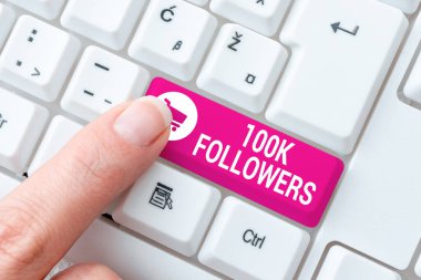 100 bin takipçiyi gösteren bir tabela. Instagram 'da Zorlu Program Kodları Yazan, Yeni Eğitim Kitabı Yazan kişi sayısı