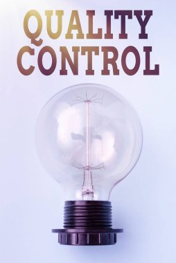 Kalite Kontrolü gösteren metin işareti. İşletme genel bakış. Üretilen ürünlerde standartları koruyan bir sistem. Lamba, sade arka planda güç kaynağı olan ve yeni fikirleri gösteren bir sistem.