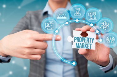 Emlak Pazarı 'nı gösteren bir tabela. Arazi ve binaların alınıp satılması fikri. İş kadını, yapboz parçasını işaret ediyor. Yeni Geleceğin Teknolojisi 'nin kilidini açıyor..