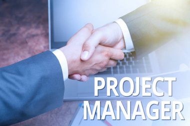Proje Yöneticisini sunan metin başlığı. İki Profesyonel İyi Giyimli İşadamı Kapalı Kapılar Arasında El sıkışma Projesi 'nin planlanması ve yürütülmesi için iş yaklaşımı