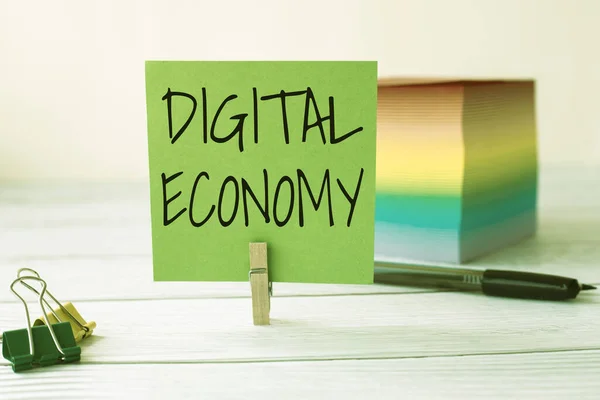 Handwriting text Digital Economy. Word Written on economic activities that are based on digital technologies Blank Sticky Note Laundry Clip Stack Of Colorful Paper Pen Placed On Desk. — Stock Photo, Image