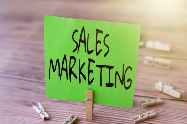 El yazısı tabelası Satış Pazarlama. Ticari konsept işlemleri ve ürünlerin tanıtımı ve satışı ile ilgili faaliyetler Yeni Anlamı Gösteren Çamaşır Klipleriyle çevrili Boş Meydan Notu.