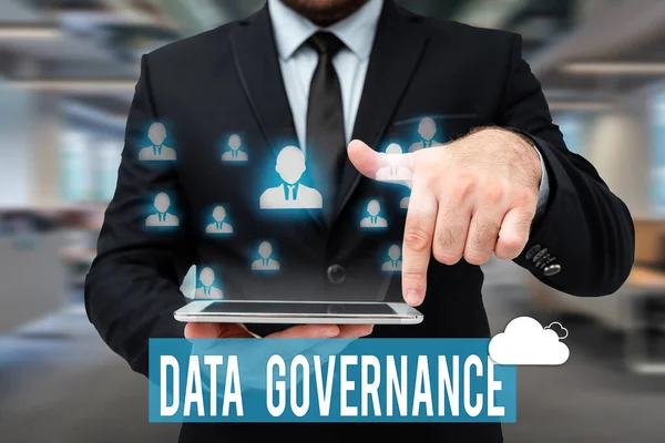 Handwriting text Data Governance. Internet Concept general management of key data resources in a company Man In Uniform Standing Holding Tablet Typing Futuristic Technologies.