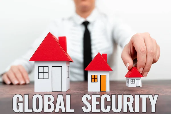 Firma mostrando Seguridad Global. Negocios muestran protección del mundo contra la guerra y otras amenazas Diferentes planes para casas representadas por mujeres de negocios — Foto de Stock