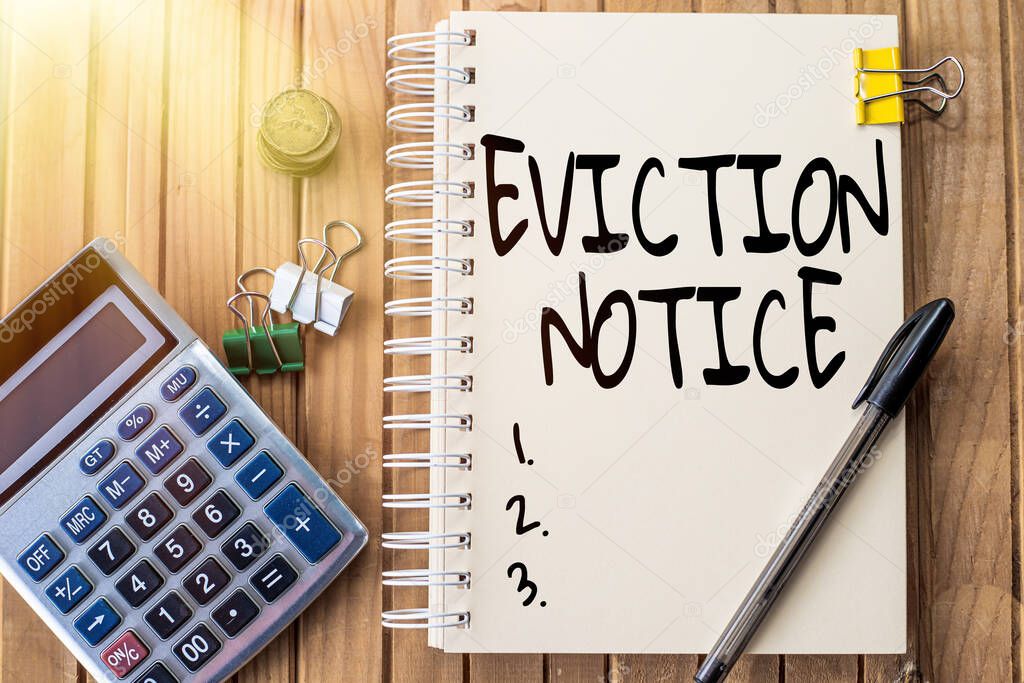 Handwriting text Eviction Notice. Word for an advance notice that someone must leave a property Plain Spiral Notebook With Pen Beside Calculator And Coins On Table.