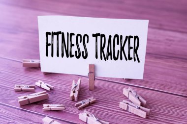 El yazısı, Fitness Tracker. Yeni Anlamı Gösteren Çamaşır Kırpma Klipleri ile çevrili bir kişinin günlük fiziksel aktivitesini kaydeden İnternet Kavram Aygıtı.