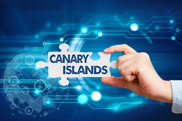 Υπογραφή: Κανάριοι Νήσοι. Επιχειρηματική επισκόπηση μιας ομάδας ορεινών νησιών στον Ατλαντικό Ωκεανό χέρι κρατώντας παζλ κομμάτι Ξεκλειδώνοντας νέες φουτουριστικές τεχνολογίες. — Φωτογραφία Αρχείου