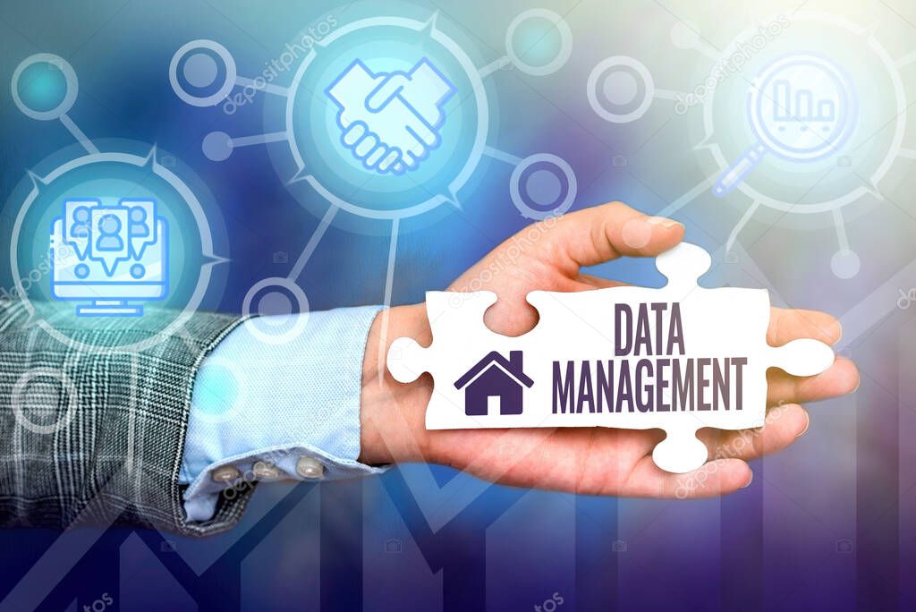 Hand writing sign Data Management. Internet Concept The practice of organizing and maintaining data processes Hand Holding Jigsaw Puzzle Piece Unlocking New Futuristic Technologies.