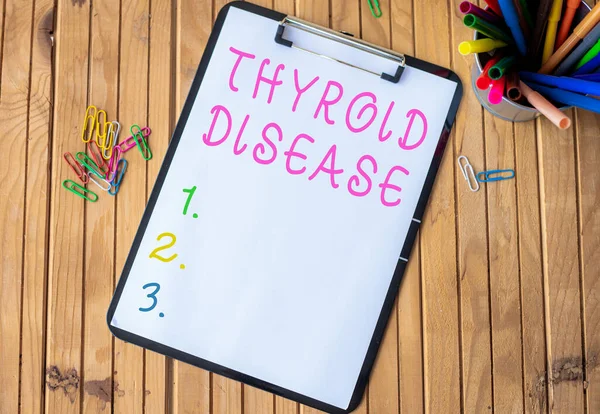 Text caption presenting Thyroid Disease. Business concept the thyroid gland fails to produce enough hormones Plain Office Clipboard With Stacks Of Pens In A Holder Placed On A Table.