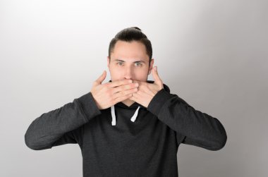 Olmaz! Ellerle ağız kapsayan ve kamera beyaz arka plan karşı dururken bakarak resmi kıyafeti şoke genç adam