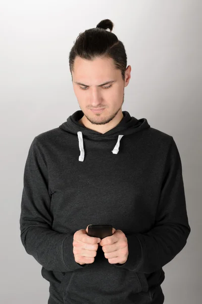 Hombre feliz usando teléfono inteligente sobre fondo gris — Foto de Stock