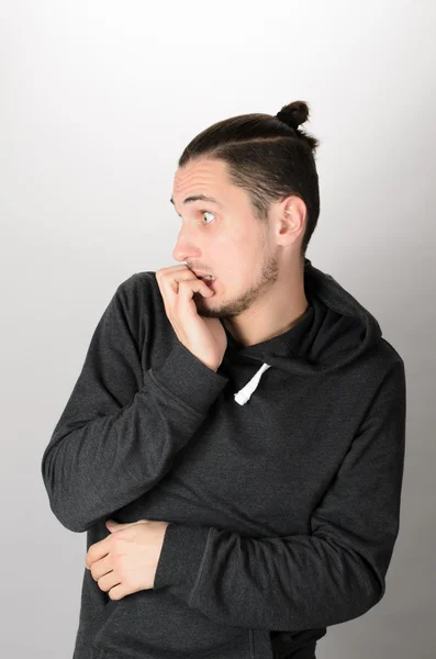 Closeup portrait of nervous, stressed young nerdy guy man with eyeglasses biting fingernails looking anxiously craving something isolated on white background. Negative emotion expression feeling — Stock Photo, Image