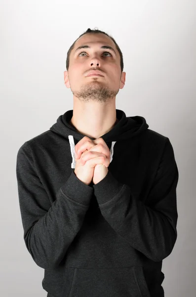 Mann betet grauen Hintergrund — Stockfoto