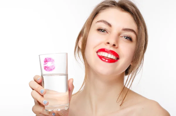 Glückliche schöne Hündin mit gesunden weißen Zähnen hält das Glas sauberen Wassers mit einem Kuss darauf — Stockfoto