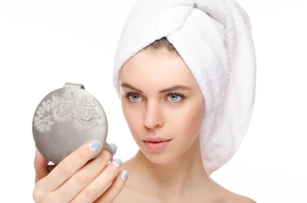 Retrato de una hermosa chica tocando con un espejo con una toalla en la cabeza — Foto de Stock