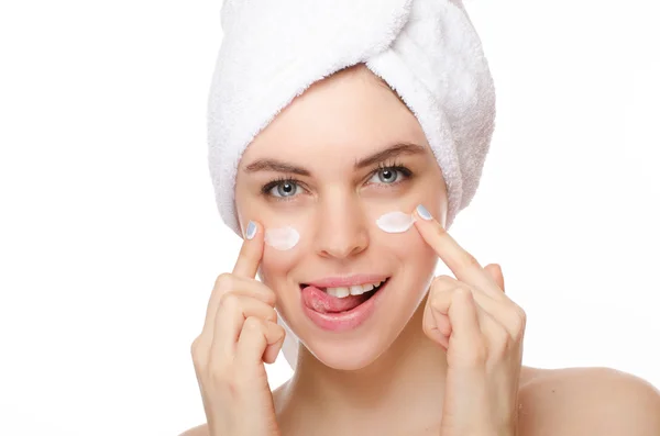 La giovane donna applica la crema cosmetica su una faccia fresca pulita da entrambe le mani — Foto Stock