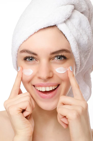 Beautiful young woman applying a creme on her face isolated on white background — Stock Photo, Image