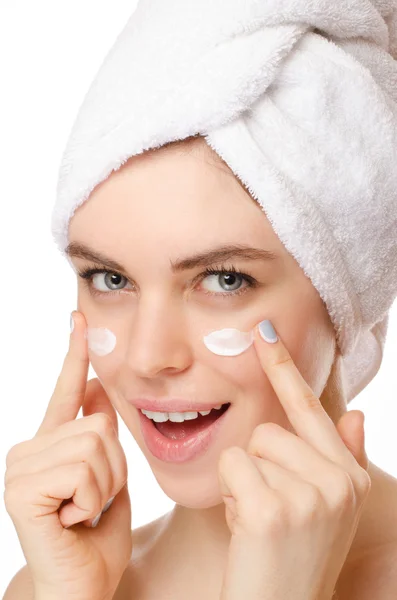 Bella giovane donna che applica una crema sul suo viso isolato su sfondo bianco — Foto Stock