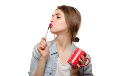 Kız yalamak kaşık çay beyaz arka plan üzerinde