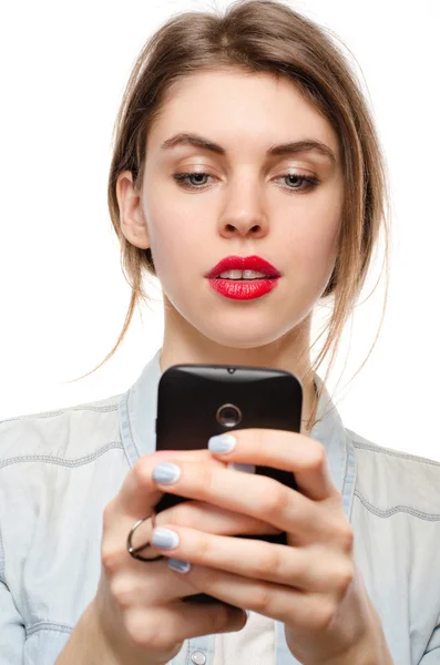 Красива молода жінка спілкується смс або кріпиться в Інтернеті за допомогою мобільного телефону, на білому тлі — стокове фото