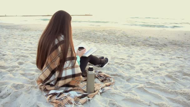 Gyönyörű nő teát inni könyvével a strandon — Stock videók