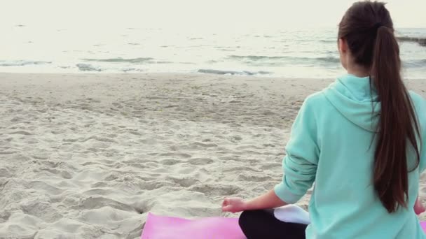 Atrakcyjna kobieta w jogi poza medytacji na plaży — Wideo stockowe