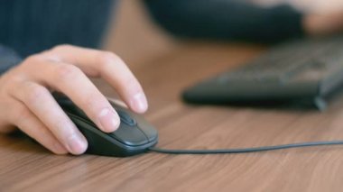 Metin klavyede yazarak fare tıklayarak bilgisayarda çalışan bir adamın elini