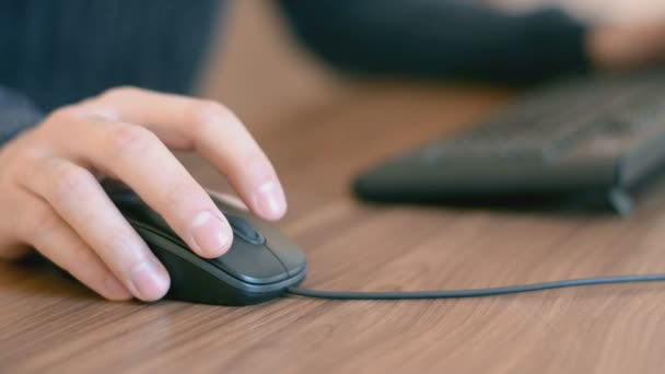 Main d'un homme travaillant à l'ordinateur en cliquant sur la souris tapant du texte sur le clavier 