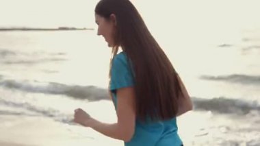 genç bir kadın deniz kıyısında koşmak yapar