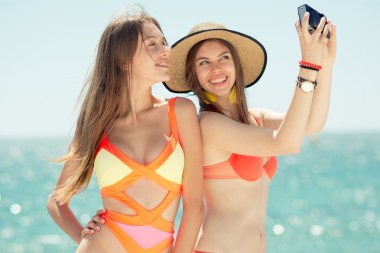 iki genç kadın selfie yapma plajda gülümseyen