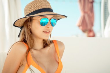 Şapka ve güneş gözlüğü rahatlatıcı seksi genç bayan