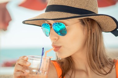 Güverte onun kokteyl beach club tutan sandalyede oturan kadın