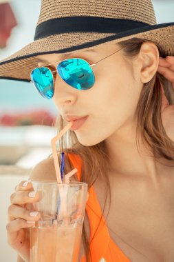 Güverte onun kokteyl beach club tutan sandalyede oturan kadın