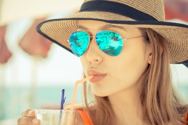 Güverte onun kokteyl beach club tutan sandalyede oturan kadın