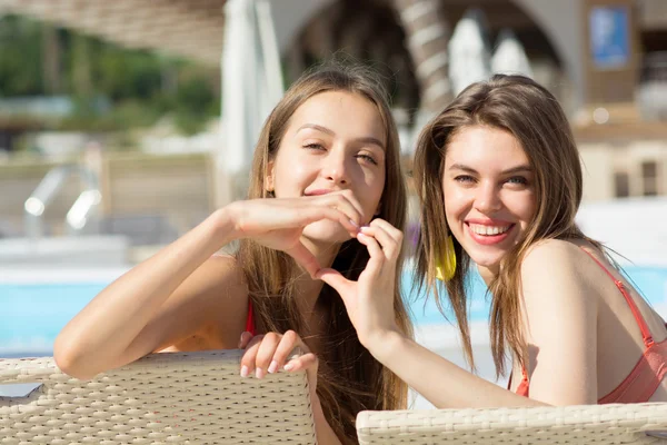 Duas meninas engraçadas na moda cool em roupa de banho em cadeiras de praia — Fotografia de Stock