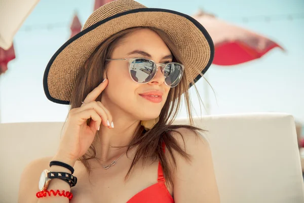 Jovem mulher de roupa de banho está posando na praia — Fotografia de Stock