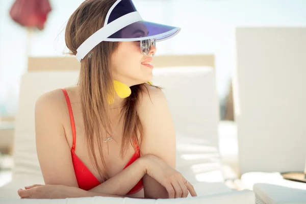 Modieuze vrouw in rode zwembroek, cap en stijlvolle zonnebril — Stockfoto