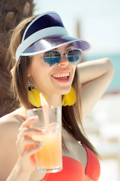 Mulher na moda em maiô vermelho, boné, óculos de sol com cocktai — Fotografia de Stock