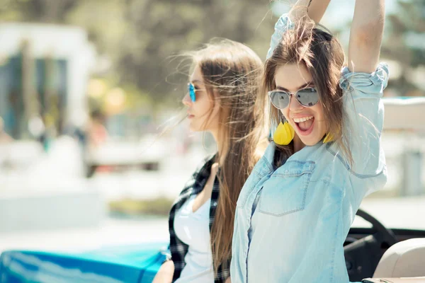 Hermosas damas en gafas de sol posando cerca de cabriole coche vintage —  Fotos de Stock