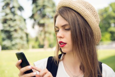Trendy bir görünüm akıllı telefon sohbet ile genç hippi kız