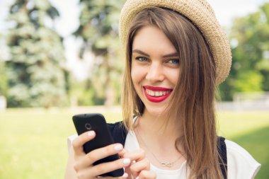 Trendy bir görünüm akıllı telefon sohbet ile genç hippi kız