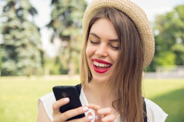 Trendy bir görünüm akıllı telefon sohbet ile genç hippi kız