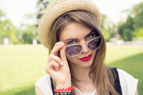 Портрет счастливой молодой девушки, сидящей в парке
