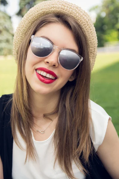 Retrato de una joven feliz sentada en el parque — Foto de Stock