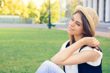 Otların arasında oturan mutlu bir genç kız portresi