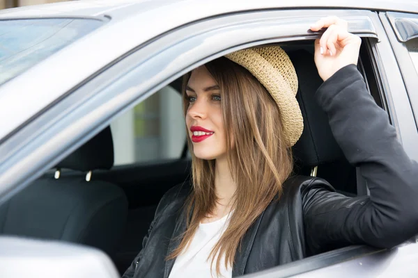 Счастливая женщина в летней шляпе за рулем автомобиля — стоковое фото