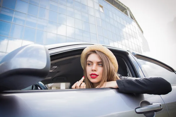 Молодая женщина наносит макияж в машине — стоковое фото